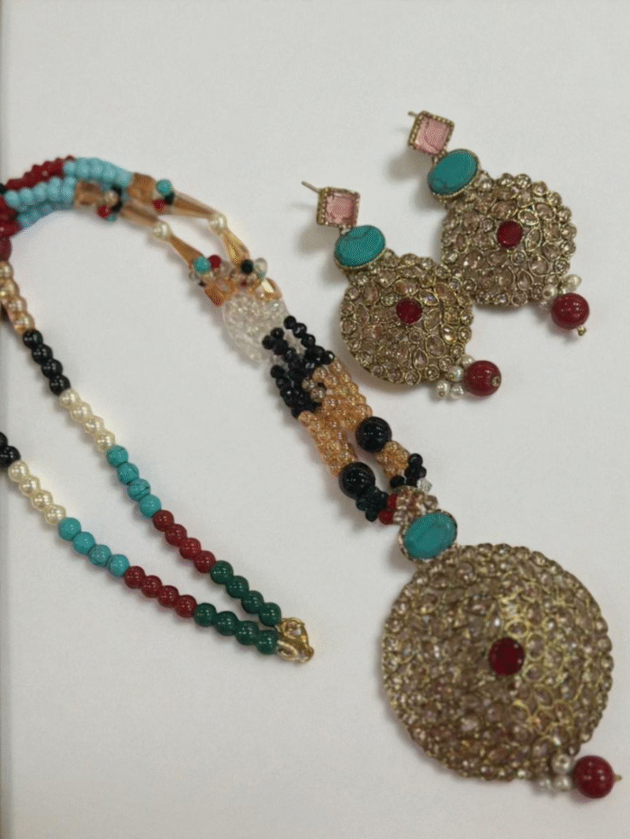 Antique gold Polki Kundan jewelry set featuring a large circular pendant and matching earrings, connected by multi-color turquoise, red, and black beaded strands.