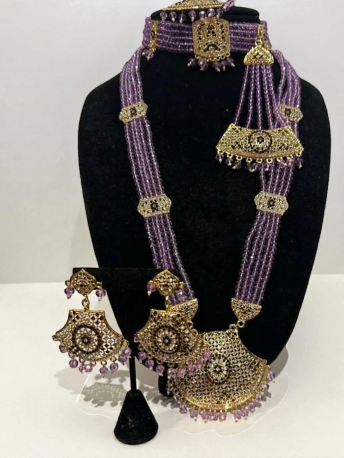 Antique gold plated Indian bridal jewelry set featuring a choker, long mala, earrings, and headpieces, all made with multiple strands of lavender beads and heavy filigree work