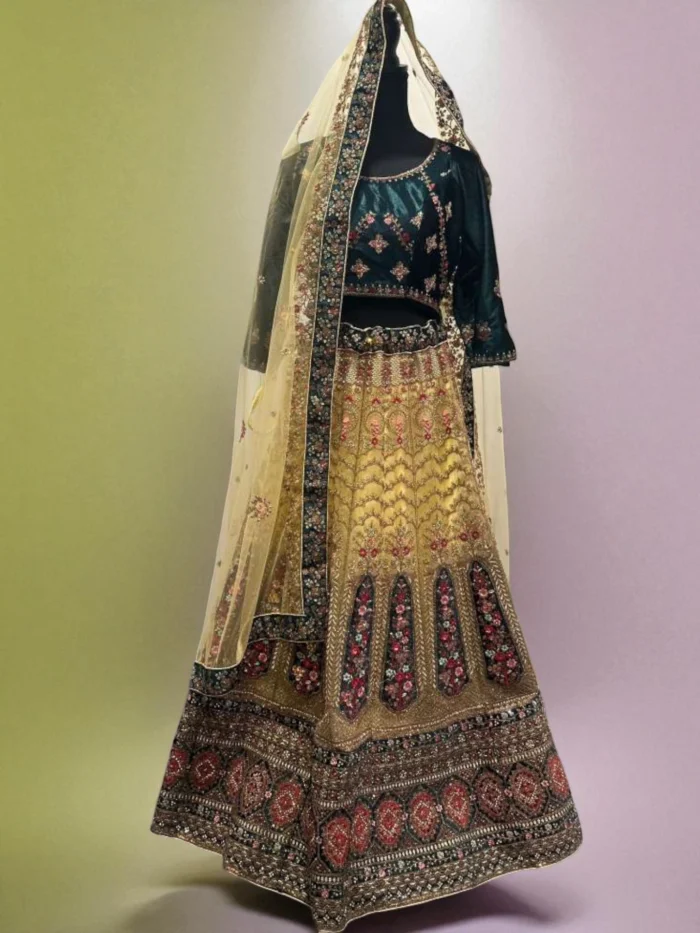 Magnificent heavy embroidered Indian lehenga set with a dark green velvet blouse, gold net skirt, and multi-color floral zardozi work.