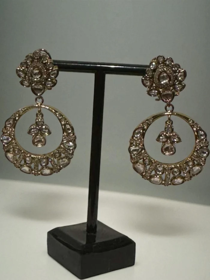 Antique gold plated oversized Chand Bali earrings set with Polki Kundan stones, featuring a floral stud and a small crystal drop suspended inside the main hoop.
