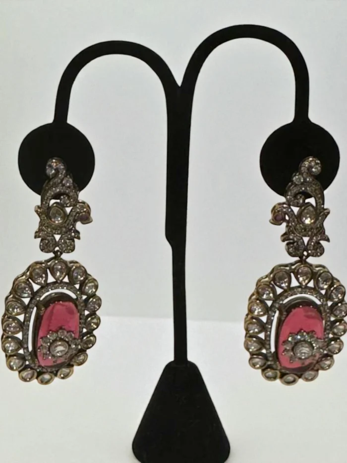 Antique gold Pachhi Kundan drop earrings with a large oval ruby red doublet stone and a halo of clear crystals.
