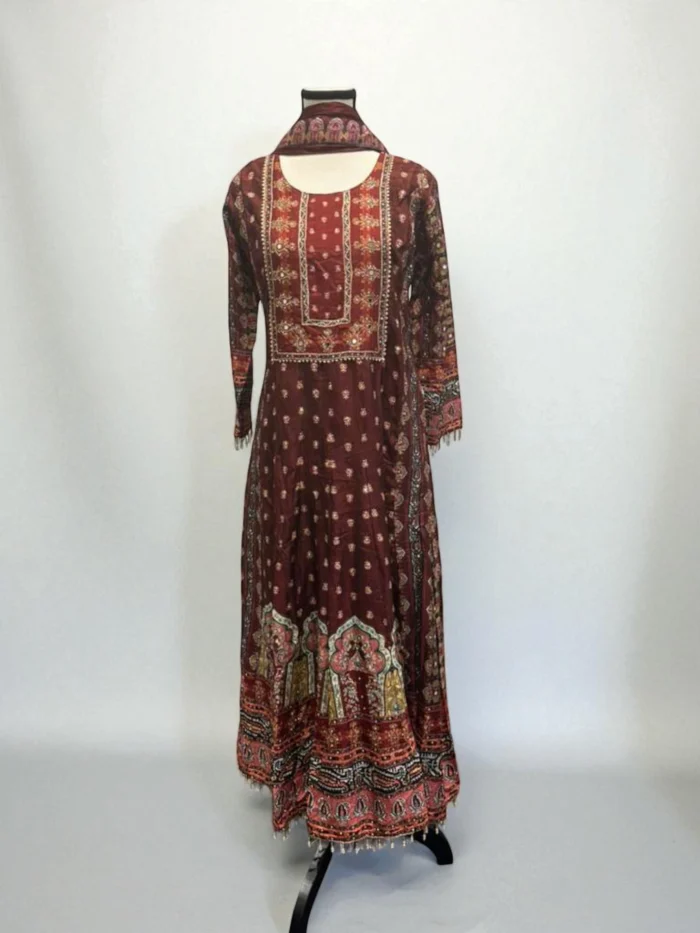 Maroon long-sleeved silk maxi dress with heavy multi-color embroidery, mirror work, and beaded tassels along the hem.