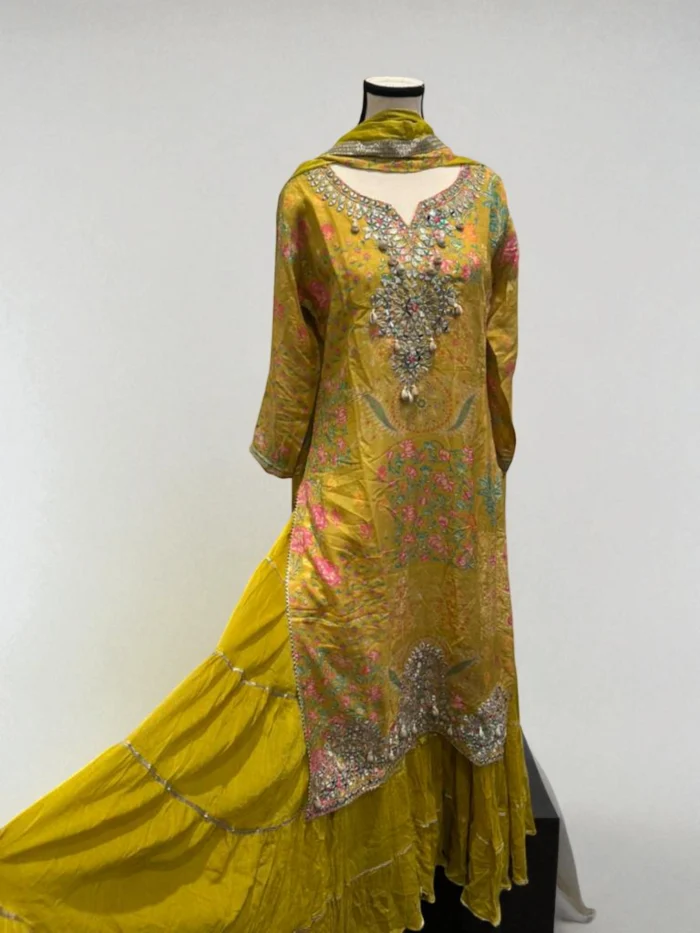 Bright yellow muslin tiered dress with multi-color floral print and mirror work neckline.