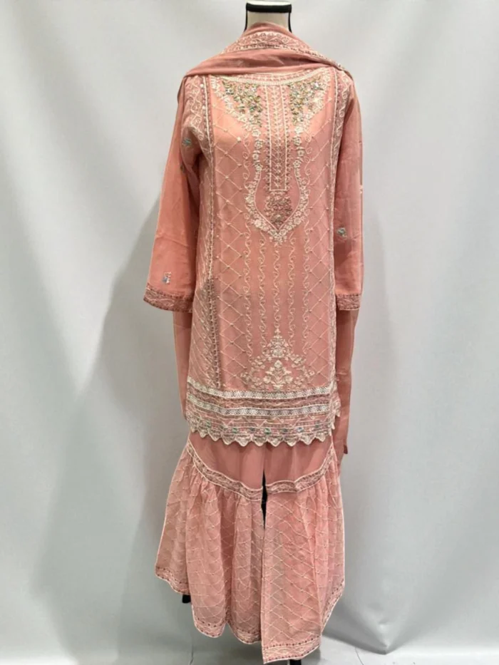 Blush pink chiffon gharara suit with white thread embroidery, multicolor hand work on the neckline, and a voluminous tiered gharara pant.