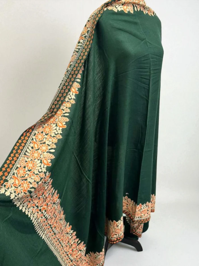 Long emerald green Kashmiri pashmina shawl with heavy orange and beige floral embroidery along the borders.