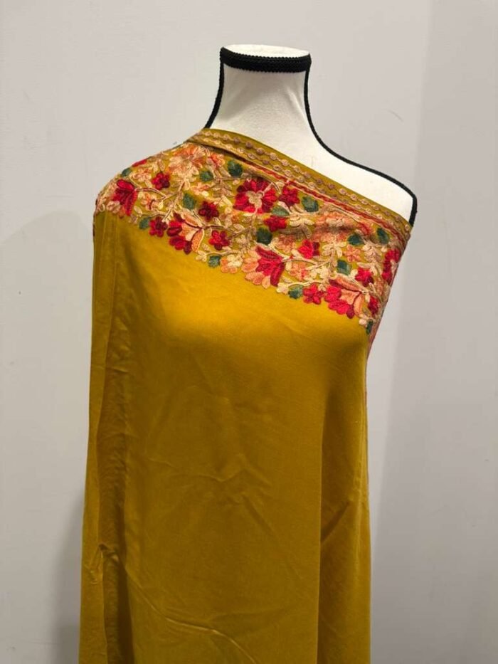 Long mustard yellow Kashmiri pashmina shawl with heavy, vibrant multi-color floral embroidery along the borders.