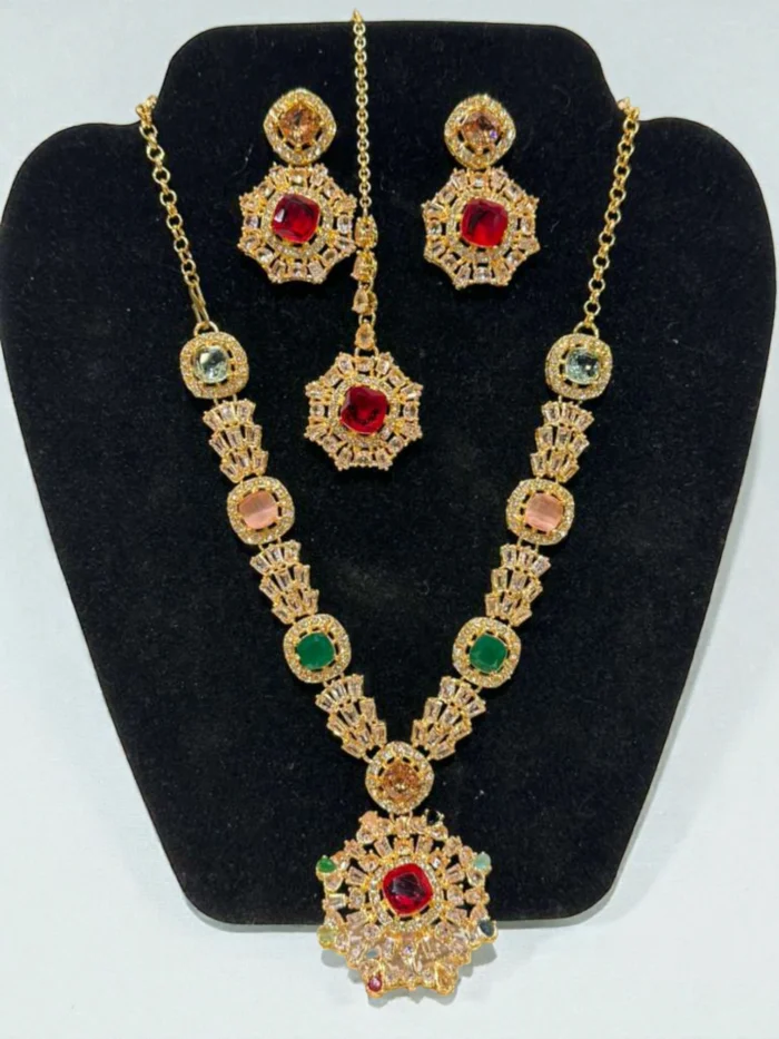Gold plated multi-color AD stone necklace set, including matching stud earrings and a forehead pendant (tika), displayed on a black velvet jewelry bust.