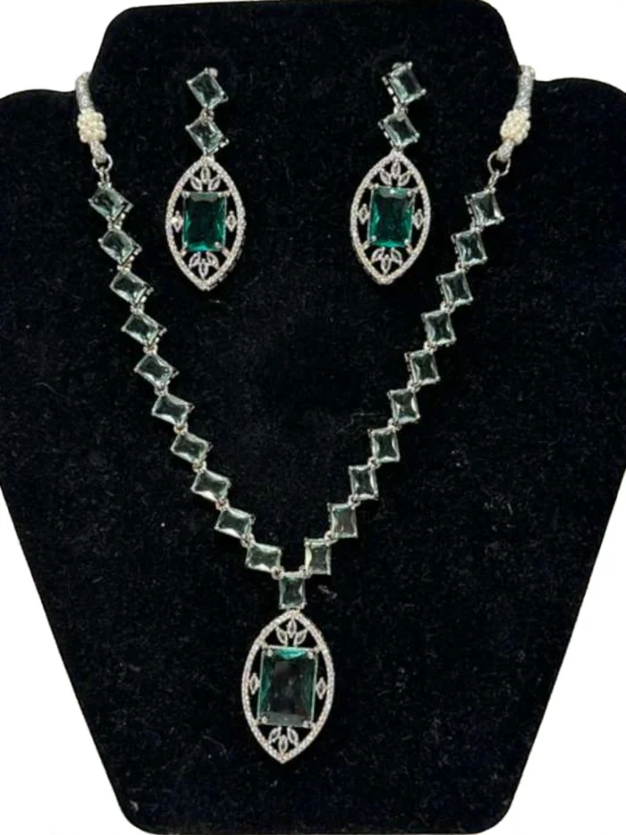 American Diamond necklace and earring set in silver polish with bright ice blue geometric and oval stones, displayed on a black velvet jewelry bust.