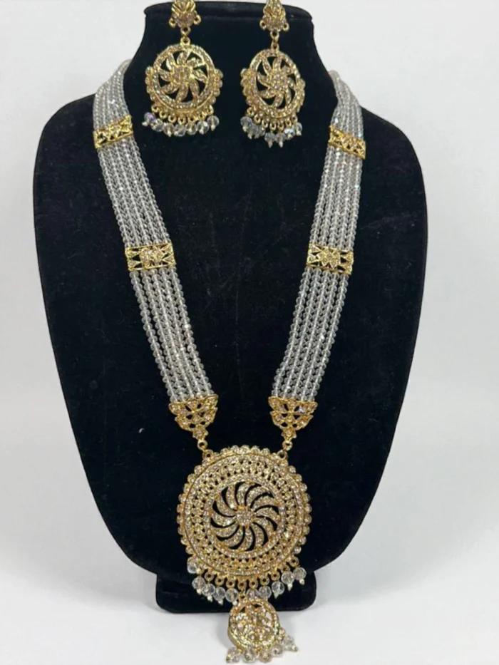 Gold plated Indian Pandit Mala necklace set featuring multi-strand grey crystal beads, a large circular AD stone pendant, and matching circular dangle earrings, displayed on a black jewelry bust.