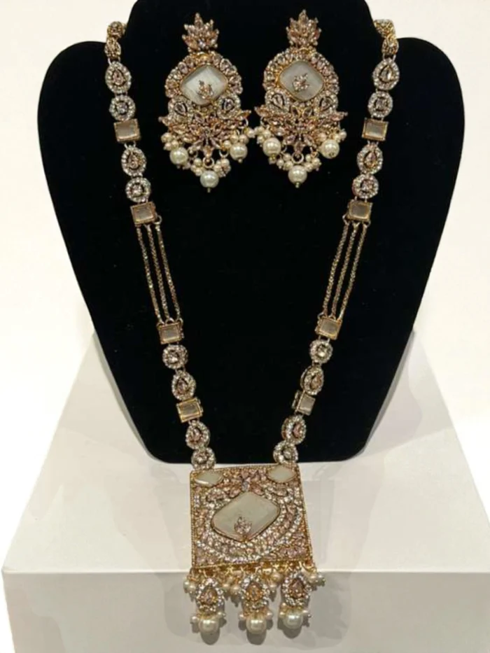 Gold plated long mala necklace set featuring a large square milky white stone pendant and linked AD/Kundan stones, with matching dangle earrings and pearl drops.
