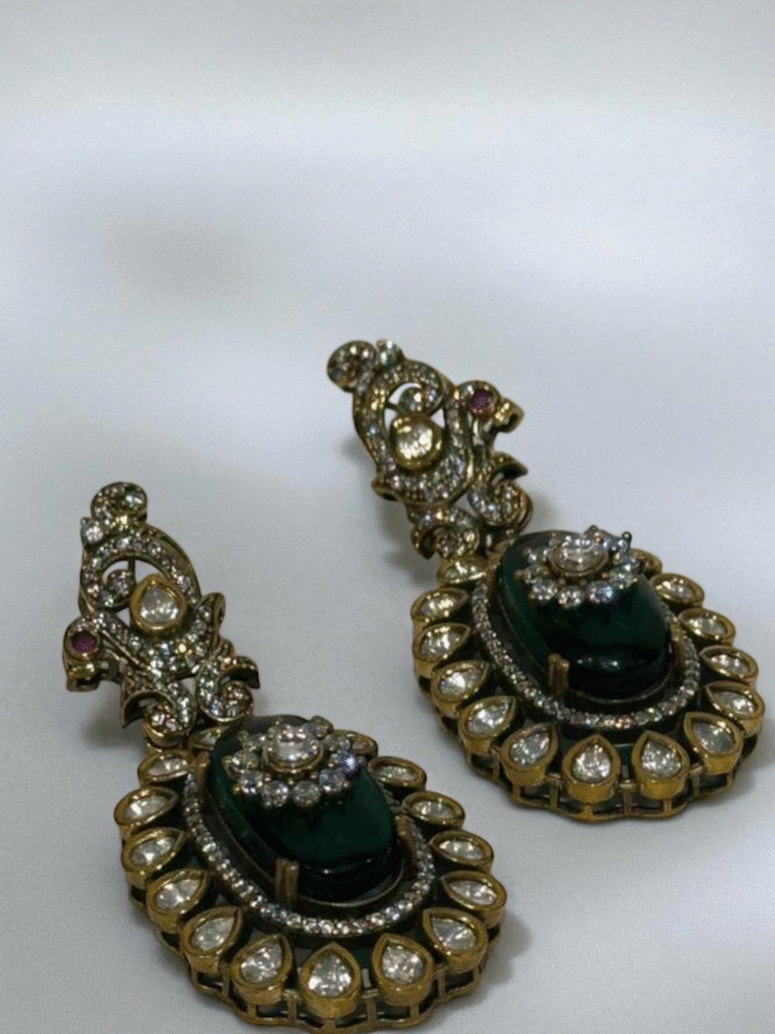 Antique gold Pachhi Kundan earrings with a large central emerald green doublet stone surrounded by clear teardrop crystals.
