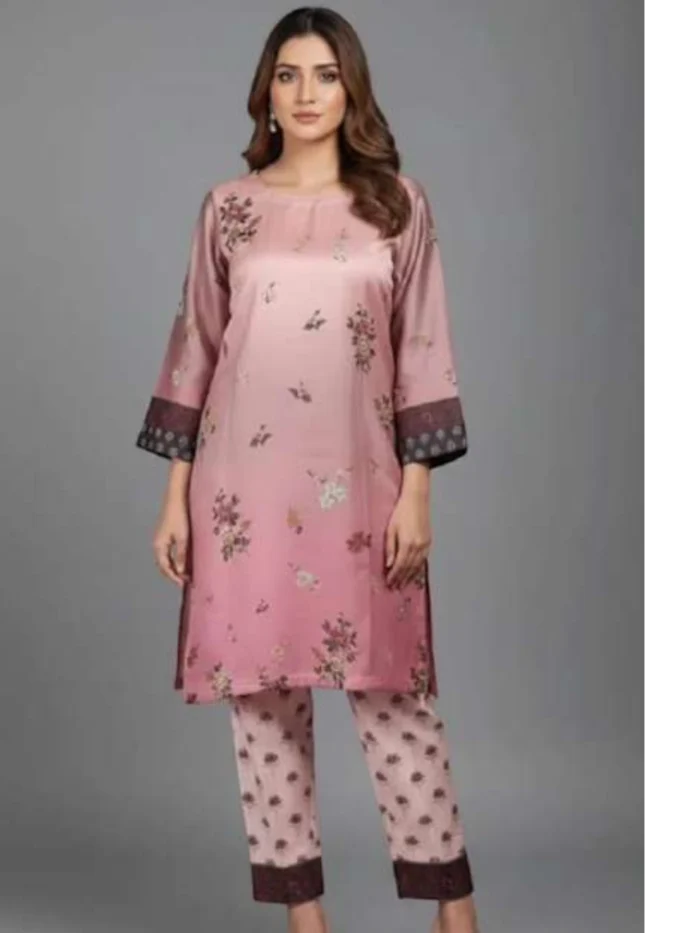 Female model wearing a soft pink ombre silk straight Kurta with small scattered floral print and dark contrast borders, paired with matching printed trousers.